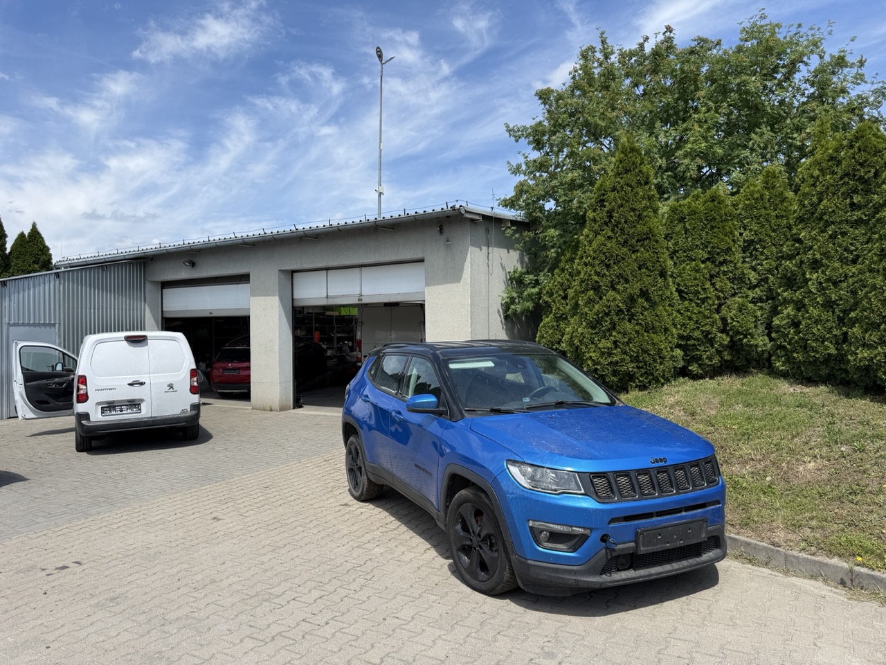 Blacharnia GP Nysa — Jeep Compass i furgon Peugeot przed bramami warsztatu